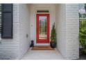 A bright red front door with glass panel, framed by white brick and complemented by a 'welcome' mat at 1059 Rockford Township Sw Dr, Marietta, GA 30064