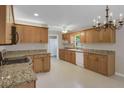 Well-lit kitchen featuring granite countertops, wood cabinets, updated appliances, and tile flooring at 4102 Barr Cir, Tucker, GA 30084