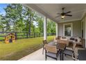 Inviting covered patio featuring comfortable seating, ceiling fan, and a view of the expansive backyard at 4960 Iris St, Cumming, GA 30040