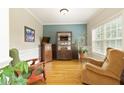 Comfortable sitting room featuring beautiful hardwood floors, wainscoting, and neutral color palette at 6765 Creek View Ln, Cumming, GA 30041