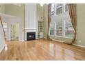 Bright living room with a fireplace, built-in shelves, and large windows with elegant curtains at 112 Rotherhithe Nw Ln, Marietta, GA 30066