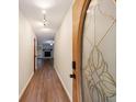 Hallway showcasing wood floors and a decorative front door leading into the living space with a fireplace at 335 Whisper Way, Dacula, GA 30019