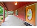 Inviting covered porch with wood floors and a charming front door with a decorative window at 335 Whisper Way, Dacula, GA 30019