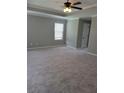 A spacious bedroom featuring neutral paint, plush carpeting, and a large window with blinds at 948 Regency Dr, Lawrenceville, GA 30044