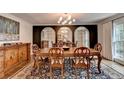 Formal dining room with wooden table, decorative rug, and a series of arched mirrors reflecting the chandelier at 5105 Vernon Oaks Dr, Dunwoody, GA 30338