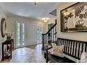 Inviting foyer with tile flooring, elegant lighting, staircase, and ample natural light streaming through the front door at 5105 Vernon Oaks Dr, Dunwoody, GA 30338