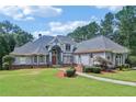Imposing facade of a luxury home, featuring a manicured lawn, inviting walkway, and a unique architectural design at 1213 Grande Vw, Loganville, GA 30052