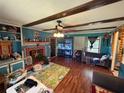 Cozy living room with exposed beams, a brick fireplace, and hardwood floors at 4147 Scofield Pl, Stonecrest, GA 30083