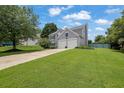 Well-kept two-story home with a spacious lawn, mature trees, and a driveway leading to the garage at 7325 Brookwood Way, Cumming, GA 30041