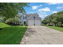 Inviting home with a manicured lawn, mature trees, and a long driveway leading to a two-car garage at 7325 Brookwood Way, Cumming, GA 30041