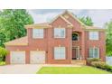 Beautiful two-story brick home featuring a manicured lawn and a three car garage at 10950 Glenhurst, Duluth, GA 30097