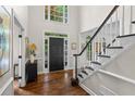 Elegant foyer features hardwood floors, a staircase, and natural light streaming through large windows at 605 Linkside Hollow, Alpharetta, GA 30005