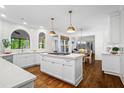 Bright, open kitchen with a center island, white cabinetry, stainless steel appliances, and hardwood floors at 605 Linkside Hollow, Alpharetta, GA 30005