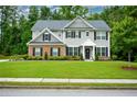 Classic two-story house with gray siding, brick details, and a well-kept lawn, perfect for Gathering living at 325 Paces Dr, Lithia Springs, GA 30122