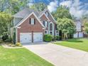 Two-story brick home with a manicured lawn, two car garage, and a large front window at 4157 Berkeley Nw Lndg, Kennesaw, GA 30144
