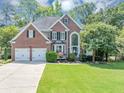 Two-story brick home with a manicured lawn, two car garage, and a large front window at 4157 Berkeley Nw Lndg, Kennesaw, GA 30144