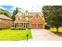 Beautiful two-story home featuring a blend of brick and stone, a cozy front porch, and an attached two-car garage at 4978 Arborview Pkwy, Acworth, GA 30101