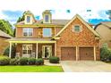 Inviting two-story home with a brick and stone exterior, a welcoming front porch, and a convenient two-car garage at 4978 Arborview Pkwy, Acworth, GA 30101