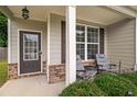Inviting front porch with seating area, brick accents, and a view of the lush front yard at 560 Vandenburg Dr, Villa Rica, GA 30180