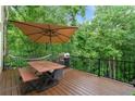 Wooden deck with patio furniture, a grill and mature trees offering shade at 1335 Joy Ct, Suwanee, GA 30024
