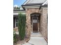 Stone porch entrance with a craftsman-style wooden front door at 430 La Perla Dr, Sugar Hill, GA 30518
