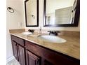 Bathroom featuring a double vanity with dark cabinets, granite countertops, and modern faucets at 958 Nevis Way, Mcdonough, GA 30253
