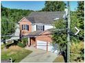 Attractive two-story brick and siding home with a two-car garage surrounded by lush trees at 1399 Cutters Mill Dr, Lithonia, GA 30058
