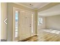 Bright entryway featuring a white front door, sidelights, and light wood-look flooring at 1399 Cutters Mill Dr, Lithonia, GA 30058