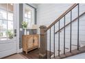 Bright foyer with a wooden cabinet, stairs, and a view of the entrance and front door at 385 Rowes Cir, Alpharetta, GA 30009