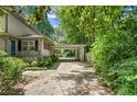 Long driveway to home featuring a covered carport surrounded by green foliage at 2839 Orion Dr, Decatur, GA 30033