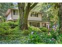 Two-story home surrounded by mature trees and vibrant hydrangeas adding charm to the landscape at 2839 Orion Dr, Decatur, GA 30033