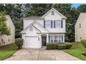 Two-story home featuring white stucco, attached garage, blue shutters, and a well-kept front lawn at 2894 Regent Walk Dr, Duluth, GA 30096