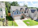 Well-maintained brick and blue home with attached garage, lovely landscaping, and green lawn at 4824 Sultana Sw Way, Atlanta, GA 30331