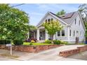 Side view of a home with a well-manicured lawn, brick retaining wall, and solar panels at 1338 Iverson Ne St, Atlanta, GA 30307