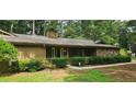 Ranch style home with stone accents, a chimney, mature trees, and front yard landscaping at 4525 N Landing Dr, Marietta, GA 30066