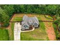 Spacious two-story home on a large fenced lot with a lush green lawn, landscaping, and long driveway at 7532 Milford Pl, Douglasville, GA 30135