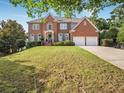 Traditional brick home with an expansive lawn and symmetrical facade at 358 Woodbrook Crst, Canton, GA 30114