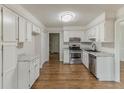 Bright kitchen featuring white cabinets, stainless steel appliances, and hardwood flooring, offering a modern and clean design at 3614 Spring Leaf Ln, Acworth, GA 30101