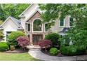 Charming two-story home with stone accents, manicured lawn, and lush landscaping, offering great curb appeal at 1850 Kirkmont Nw Dr, Marietta, GA 30064