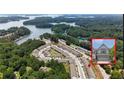Beautiful aerial view of lakeside townhomes surrounded by lush trees and glistening water at 1969 Lanier Harbor Pt, Buford, GA 30518