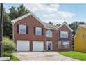 Charming two-story brick home featuring an attached two-car garage and well-manicured lawn at 2379 Fallbrook Ct, Duluth, GA 30096