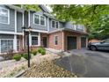View of a brick and gray townhome featuring an attached two-car garage and landscaped yard at 2680 Pine Tree Ne Rd # 2, Atlanta, GA 30324