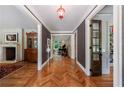 Inviting hallway with herringbone hardwood floors and views of a living room and den at 510 Heards Ferry Rd, Atlanta, GA 30328