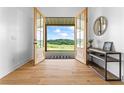 Bright foyer featuring wood floors, a console table, and a view of the landscape through French doors at 5315 Hendrix Rd, Cumming, GA 30040