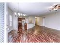Bright living area with hardwood floors, chandelier, and view of kitchen, creating an open and inviting space at 6470 Saint Mark Way, Fairburn, GA 30213
