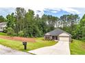 Attractive one-story home with a long driveway and lush landscaping, surrounded by mature trees at 509 Grace Ln, Villa Rica, GA 30180