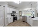 Modern kitchen features white cabinets, stainless steel appliances, and a sleek countertop at 3807 Lance Bluff Ct, Duluth, GA 30097