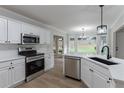 Modern kitchen features white cabinets, stainless steel appliances, and a sleek countertop at 3807 Lance Bluff Ct, Duluth, GA 30097