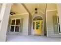 Inviting front porch featuring a vibrant yellow door and decorative accents at 8040 Banks Mill Rd, Douglasville, GA 30135