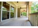 Expansive porch with wood flooring, ceiling fans, and views of the wooded outdoors at 8040 Banks Mill Rd, Douglasville, GA 30135